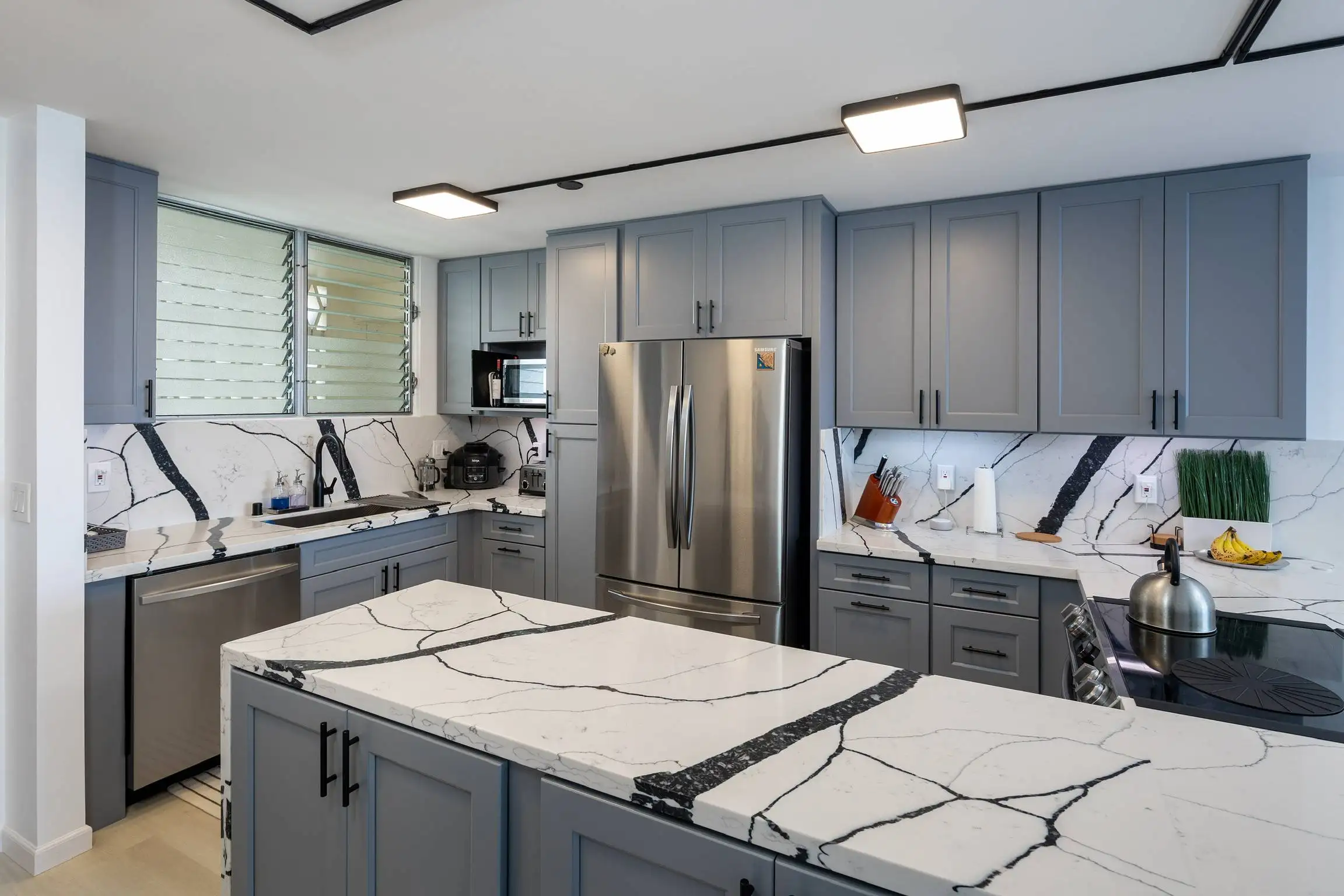 Grey shaker cabinets and veined quartz counters in a Honolulu kitchen